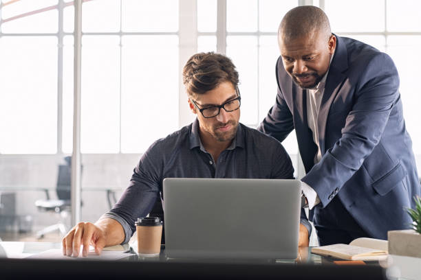 startups Business multiethnic colleagues having meeting in modern office. Smart business partners planning work together. Young businessman with boss working together on laptop.